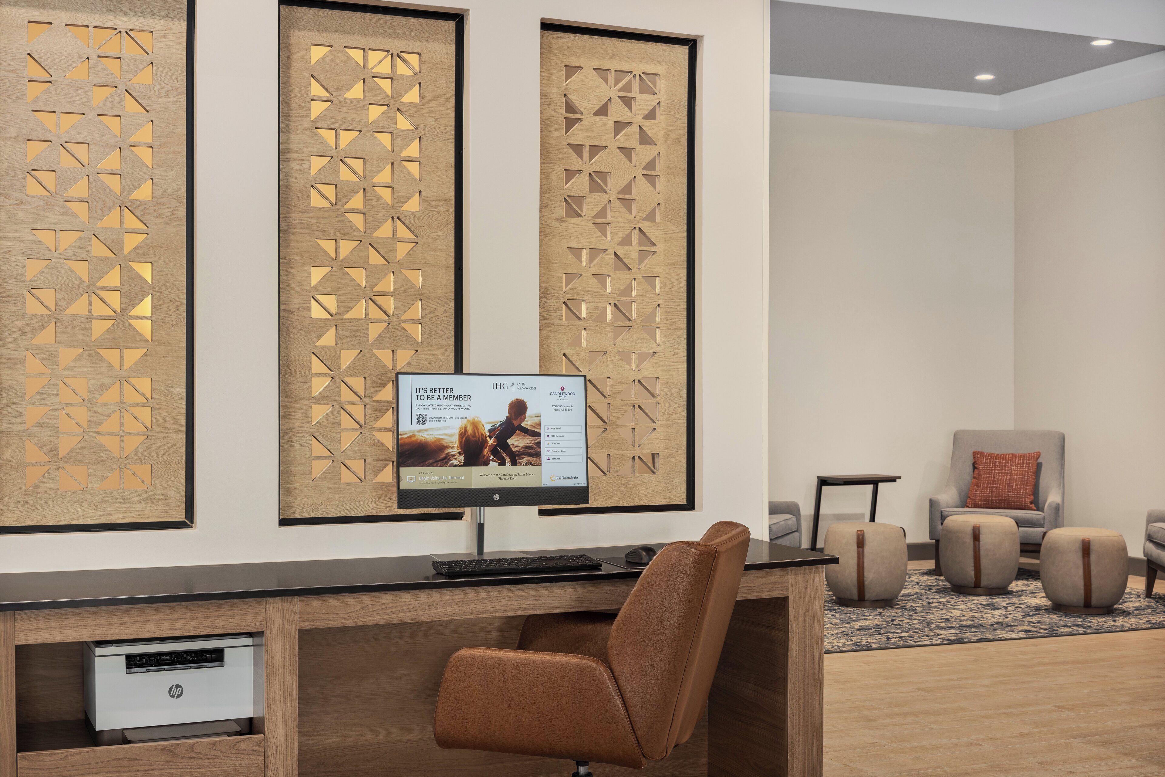 A modern office space with a desk, computer, and seating area.