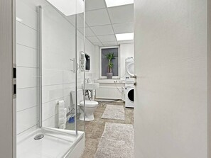 Een haardroger, handdoeken, zeep, toiletpapier