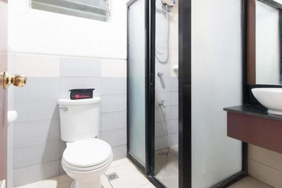 A bathroom with a toilet, a glass-enclosed shower, and a sink.
