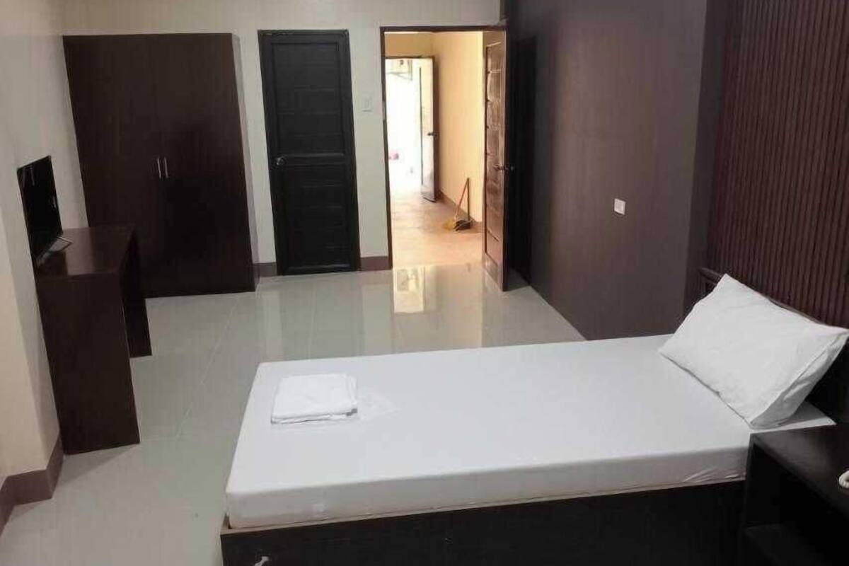 A bedroom with a bed, a desk, and two doors.