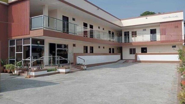 A multi-story building with a central courtyard, balconies, and a sign indicating a business or commercial use. - OYO 1122 Ranchotel Aklan (Kalibo)