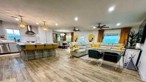 A modern living space with a kitchen, dining area, and seating area.