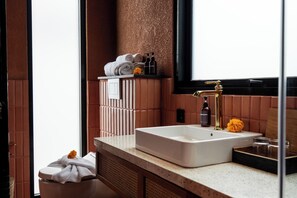 A modern bathroom with a large sink, a mirror, and a towel rack with neatly folded towels. - Earth Villa Canggu by Ini Vie Hospitality (Canggu)