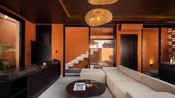Una sala de estar moderna con un sofá, una mesa de centro, un televisor y una escalera que conduce a otro nivel.