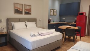 A bedroom with a bed, a bedside table, a mirror, and a small desk with a chair. - Acropolis Oasis  (Athens)