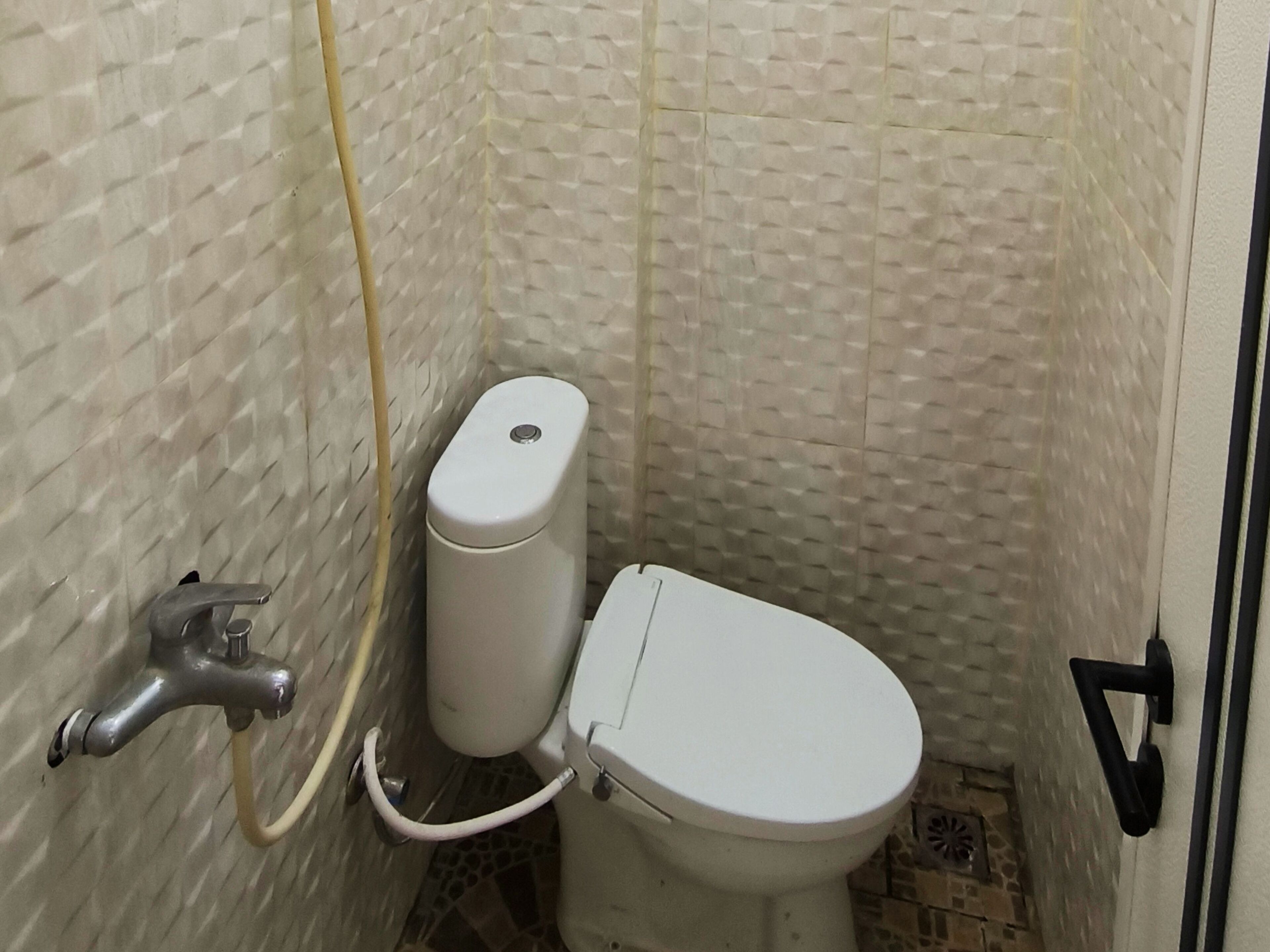 Un bagno piccolo e funzionale, con il water, un lavandino e una doccia.