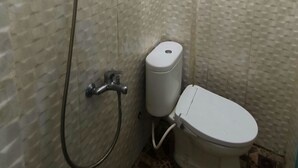 A bathroom with a toilet and a shower. - Trikora Guesthouse Syariah 1 (Pekalongan)