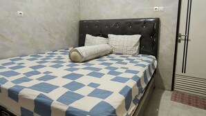 Una habitación de hotel con cama, pared de mármol y puerta.