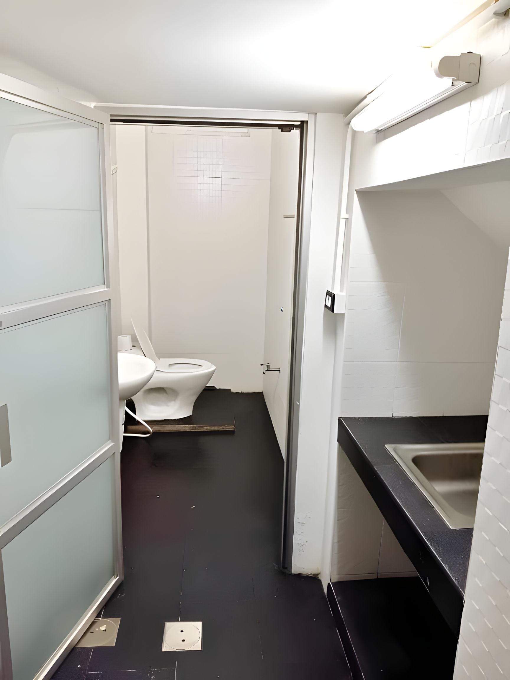 A compact bathroom with a toilet, a sink, and a mirror.