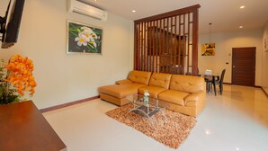 A modern living room with a leather sofa, a glass coffee table, and a decorative rug.