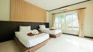 A hotel room with two beds, a large window with curtains, a ceiling fan, and a wall-mounted air conditioner.