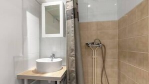 Une salle de bain avec un lavabo, un miroir et une douche.