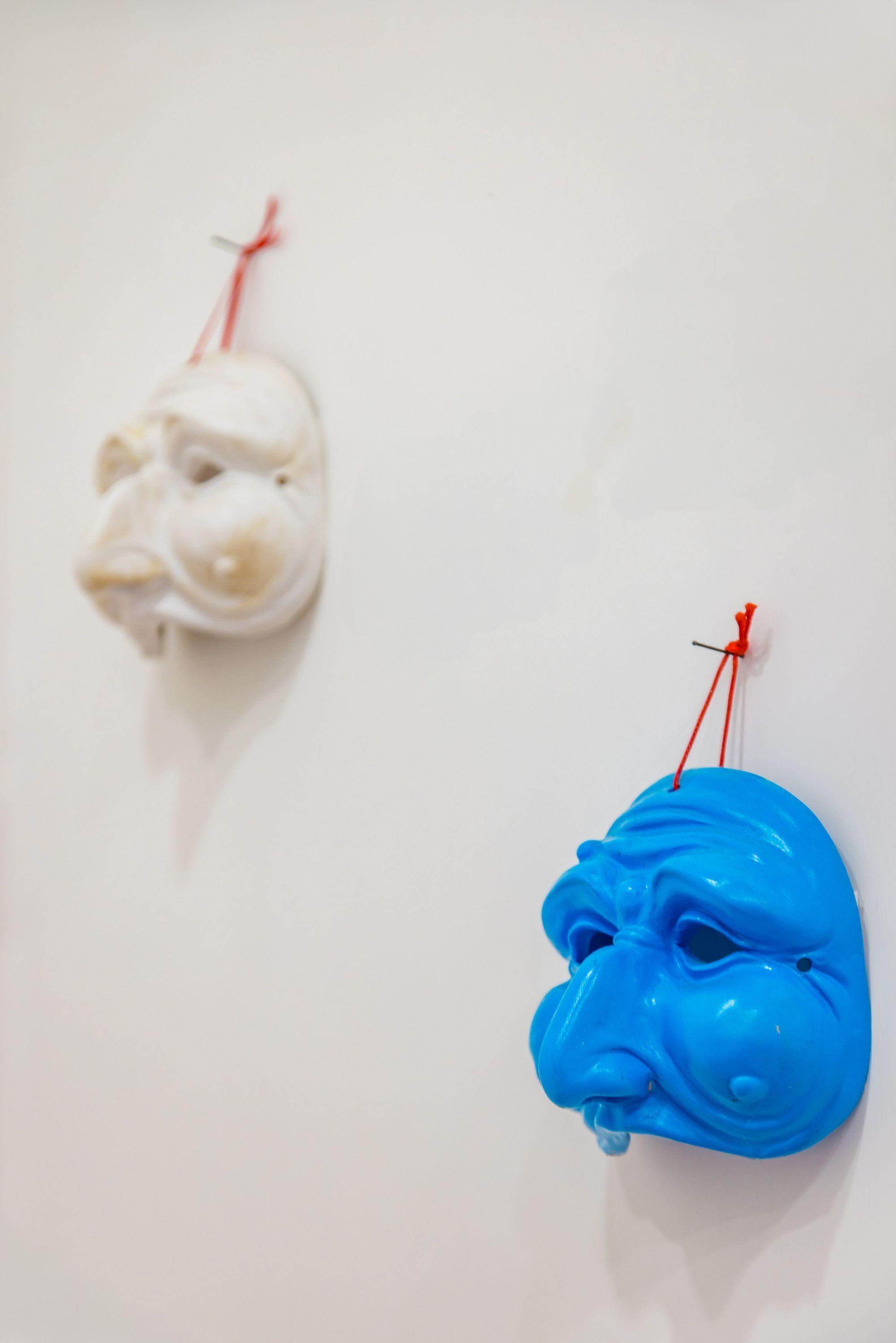 Zwei Masken hängen an einer Wand.