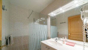 A bathroom with a shower, a sink, and a hairdryer. - Massane gîte for 2 to 8 people at Mas la Couloumine (Elne)