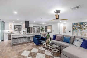 A modern kitchen with a bar area, a dining table, and a living room with a sofa and a coffee table. - The Sundancer Oasis|Old Town|Pool+Spa|Rooftop Deck (Scottsdale)