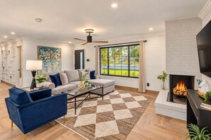 A living room with a sofa, armchair, coffee table, fireplace, and a large window with a view. - The Sundancer Oasis|Old Town|Pool+Spa|Rooftop Deck (Scottsdale)
