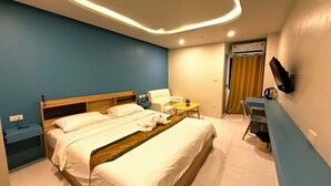A modern hotel room with a large bed, bedside tables, a desk, and a chair. - THE NICE  (Patong)