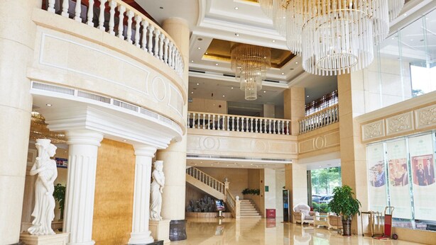 A spacious lobby with marble floors, classical columns, a grand staircase, and a chandelier. - Vienna hotel shenzhen shajing shangnan  (Shenzhen)