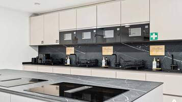 Modern Shared Kitchen with Island – Cook and connect in this sleek, fully equipped kitchen featuring premium appliances and a spacious island.