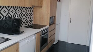 A kitchen with a dishwasher, stove, and a coffee maker.