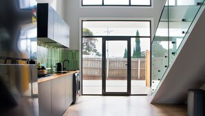 A modern kitchen with a large sliding glass door leading to an outdoor area.