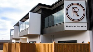 A modern building with a sign reading "REGIONAL ESCAPES" and a logo with a capital R.