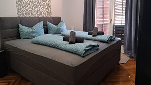 Een moderne slaapkamer met een groot bed, twee kussens en een nachtkastje.