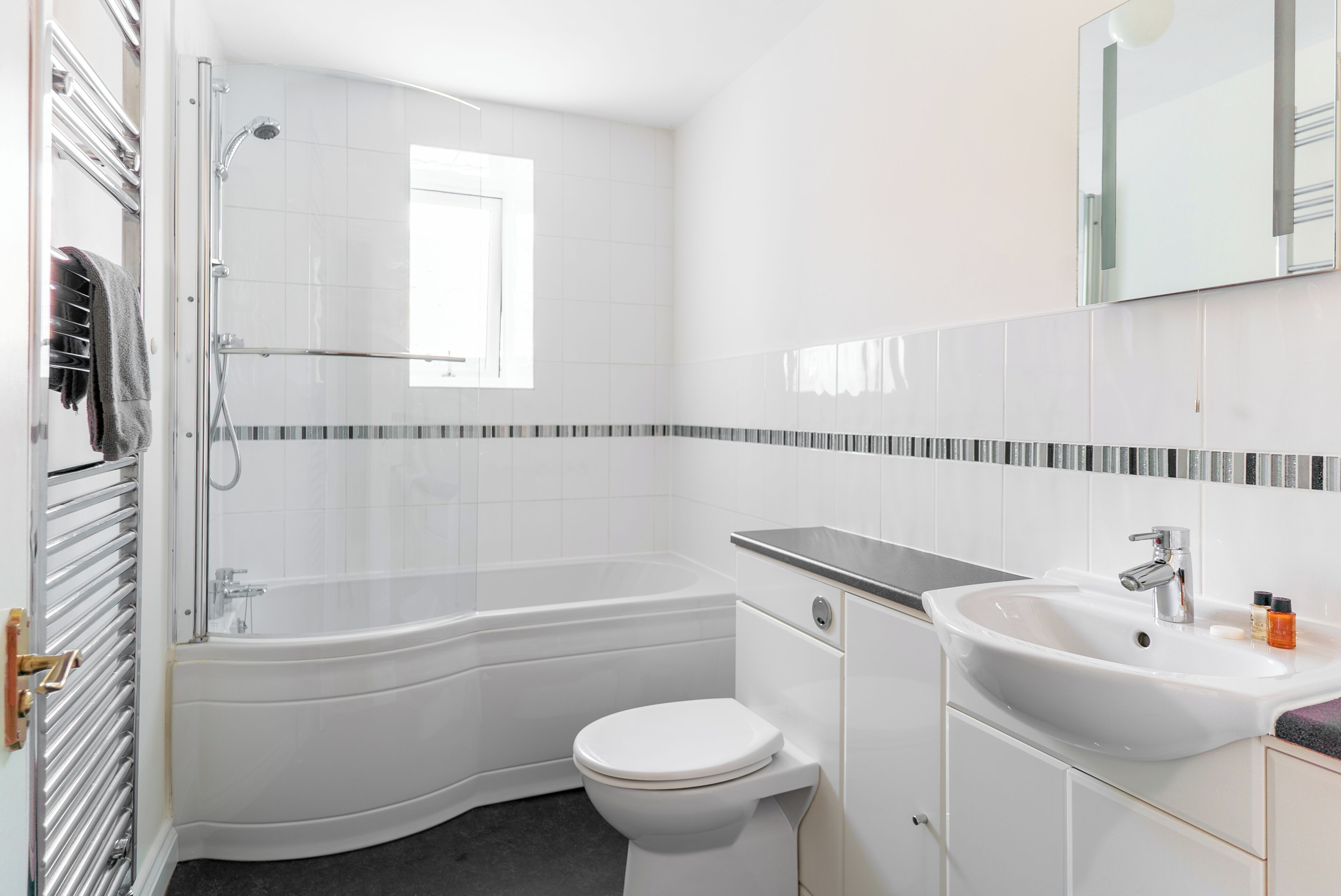 A modern bathroom with a bathtub, toilet, and sink.