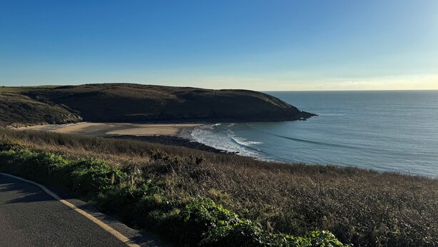 Una carretera costera con playa y acantilados.