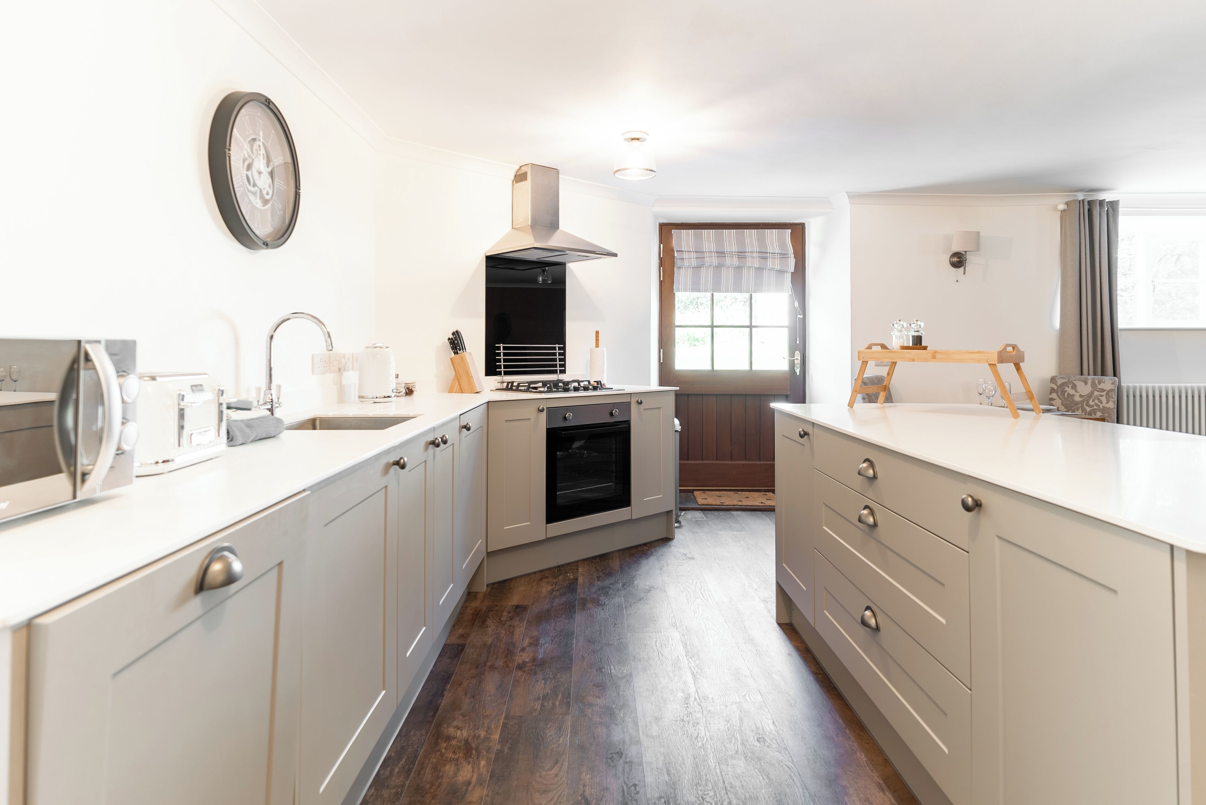 A kitchen with white cabinets, a stove, and a sink.