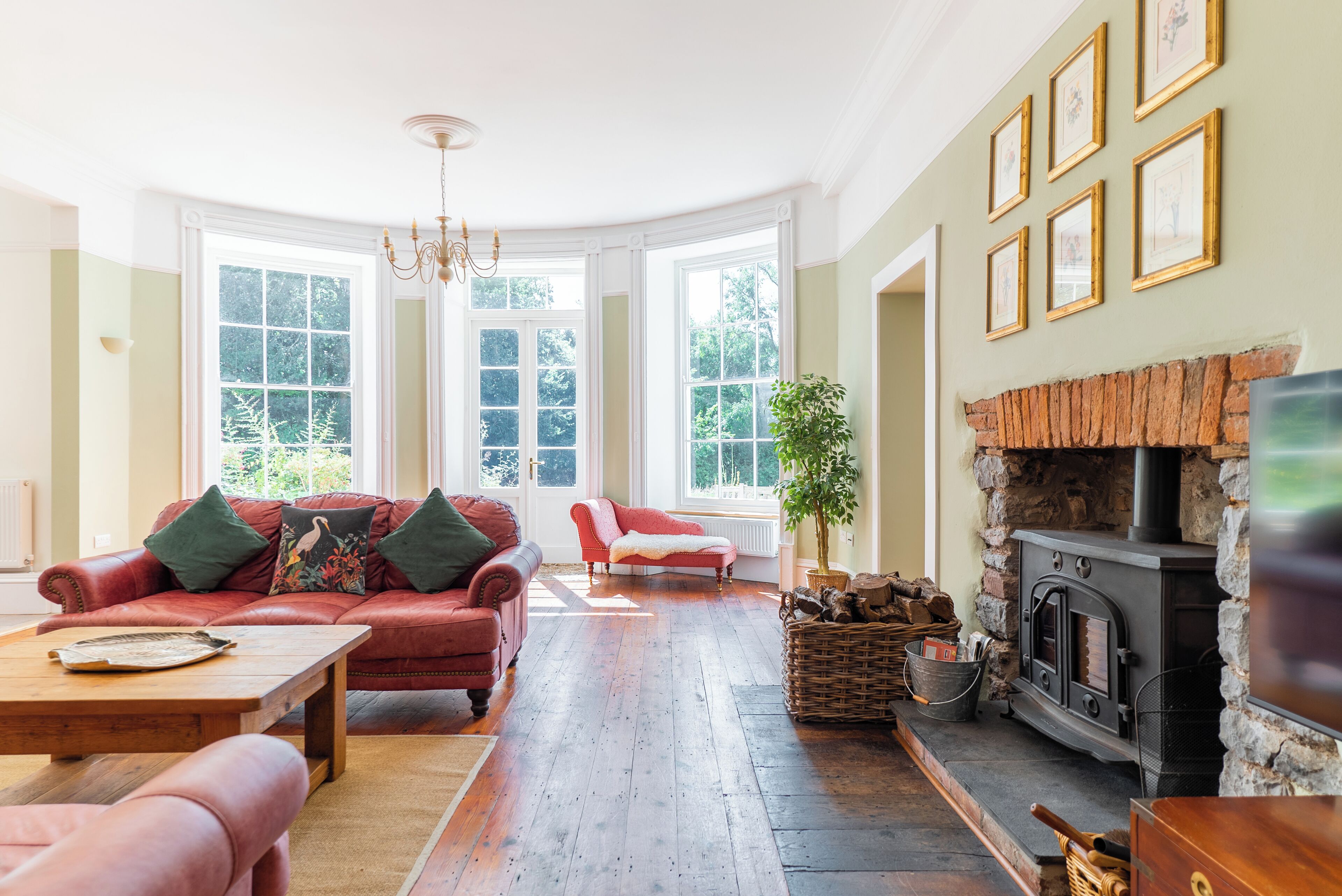 A spacious living room with a fireplace, large windows, and a cozy seating area.