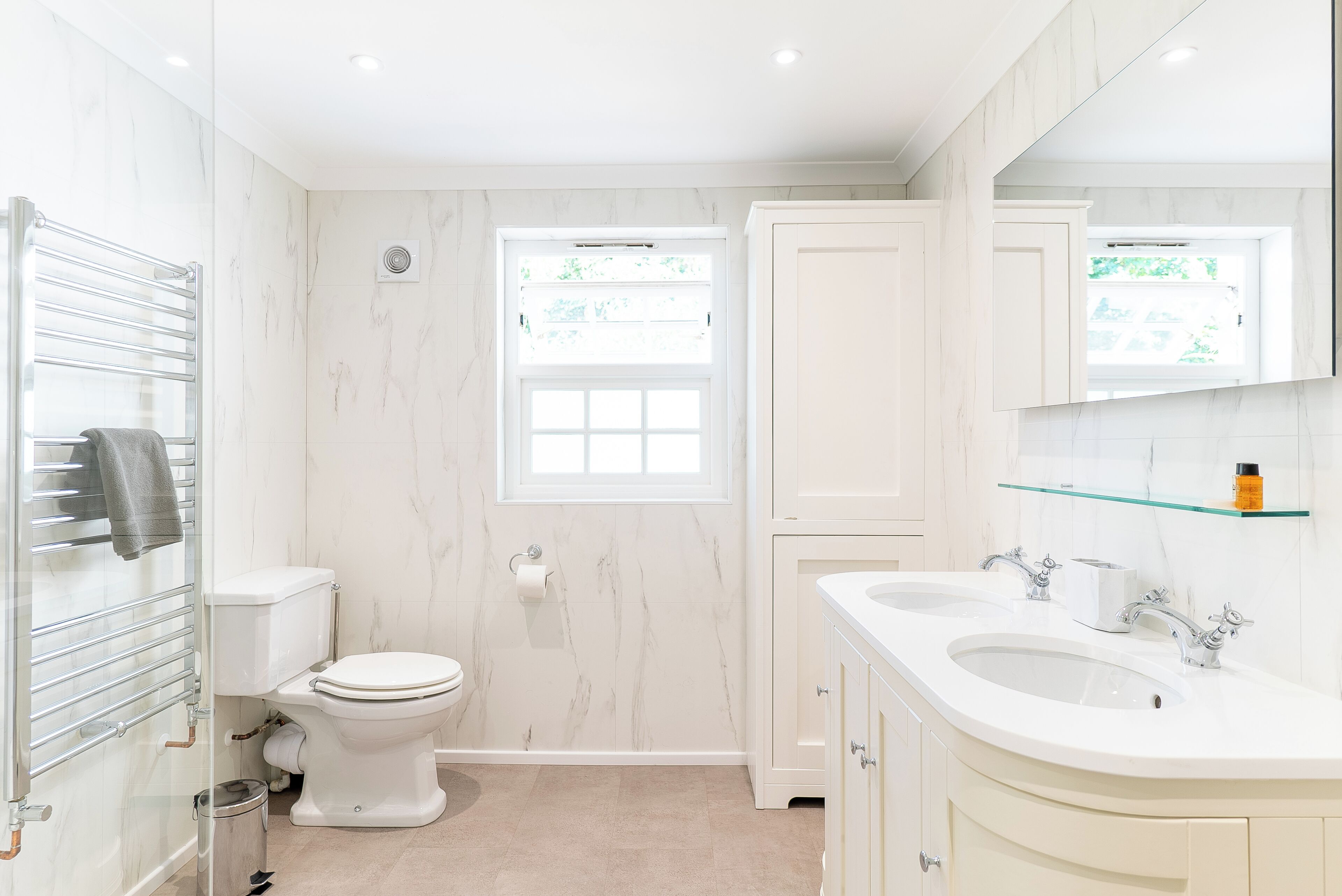 A modern bathroom with a toilet, bidet, and two sinks.