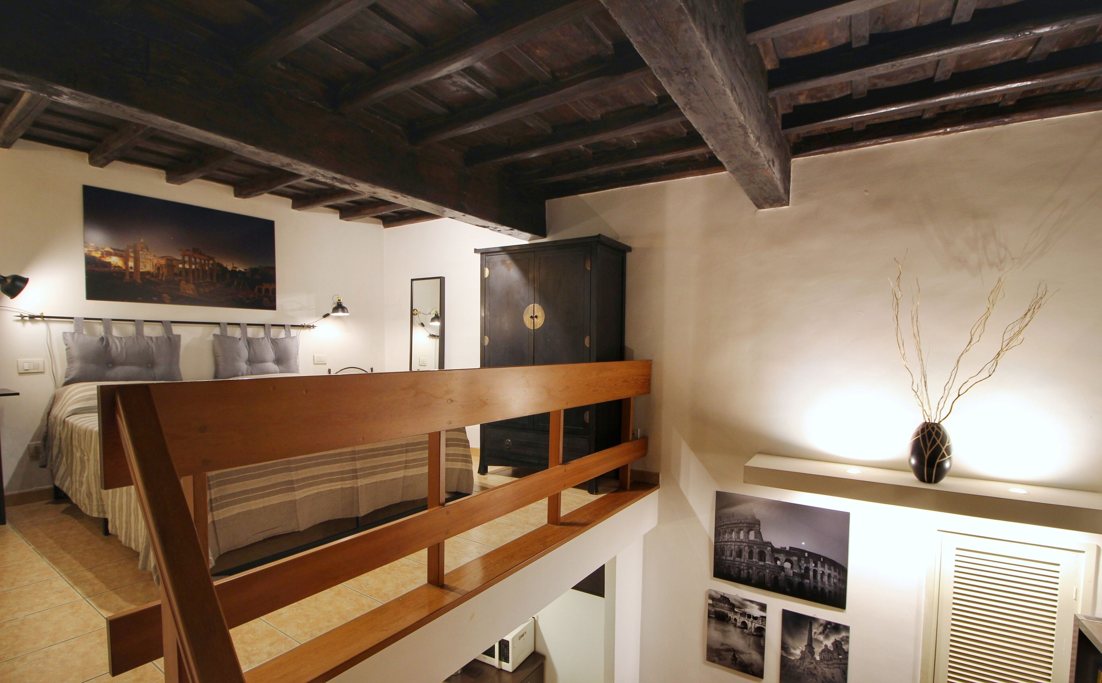A bedroom with a wooden bed frame, a nightstand, a wardrobe, and a wall-mounted shelf with decorative items.