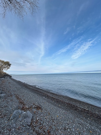 On the beach, sun-loungers, beach towels. North Coast Cottage. Located on the southern shore of Lake Ontario.