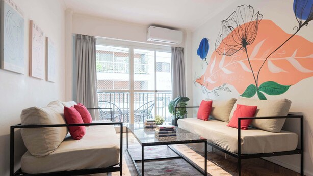 Een moderne woonkamer met een bank, een salontafel en een balkon met uitzicht.