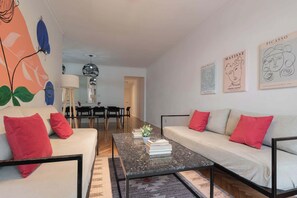 Ein modernes Wohnzimmer mit einer Couch, einem Couchtisch und Kunstwerken an den Wänden.