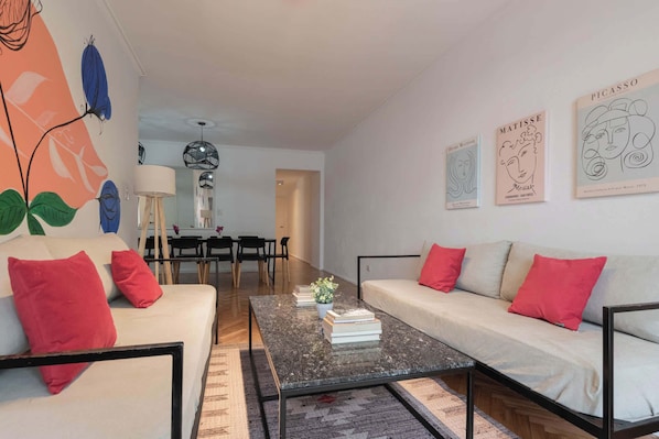 A modern living room with a sofa, coffee table, and artwork on the walls.