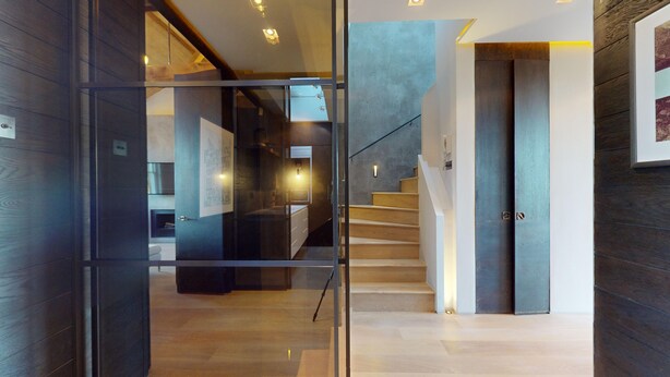 A modern interior with a glass partition, wooden staircase, and a view into another room. - 3-bedroom Penthouse in Knightbridge (London)