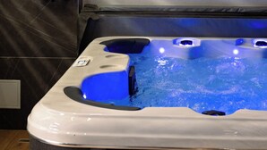 A hot tub with a built-in showerhead, set against a tiled wall. - Isabella Suites (Gzira)