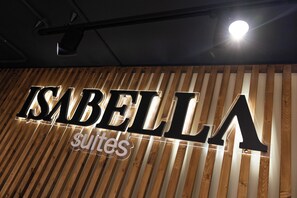 A sign with the name "ISABELLA suites" on a wooden slatted wall. - Isabella Suites (Gzira)