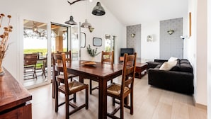 Un salon moderne avec une table à manger en bois, un canapé foncé et des murs à motifs.