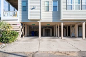 Un bâtiment à deux étages doté d’un espace de stationnement couvert et d’une enseigne indiquant « FDG ».