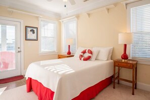 Une chambre avec un grand lit, deux tables de chevet et une porte donnant sur une vue agréable.