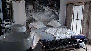 A modern bedroom with a large bed, a bedside table, a large white basin, and a window with curtains. - Grand Cru (Chardonnay)