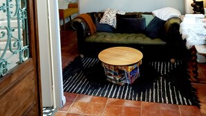 A cozy living room with a green sofa, a patterned rug, and a small wooden coffee table. - Grand Cru (Chardonnay)