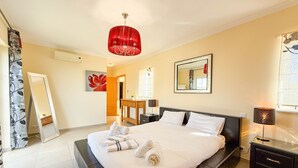 A modern bedroom with a large bed, a red pendant light, a bedside table, and a mirror on the wall. - Villa Nosredna 5 Bedroom & Pool LES01 (Ayamonte)