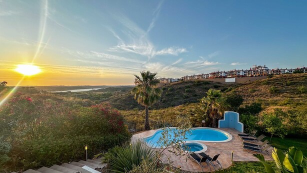 A pool area with a view of a coastal town during sunset. - Villa Nosredna 5 Bedroom & Pool LES01 (Ayamonte)