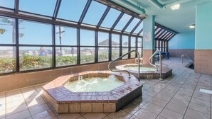 A spa area with two hot tubs, a large window with a view, and a tiled floor. - Phoenix V 910 (Orange Beach)