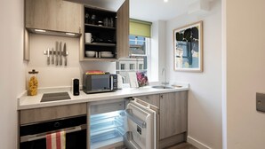 Une cuisine compacte équipée d’un four à micro-ondes, d’un grille-pain et d’un évier.
