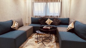 Una sala moderna con un sofá modular, una mesa de centro y una alfombra estampada.